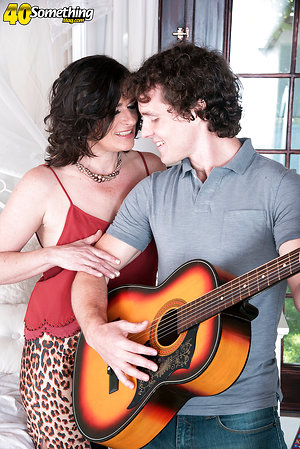 Romantic curly-haired guy fucks mature after playing guitar
